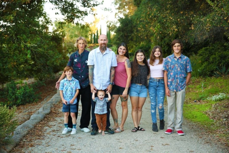 Josh Blunt with family outside - two parents and six children stand on a trail